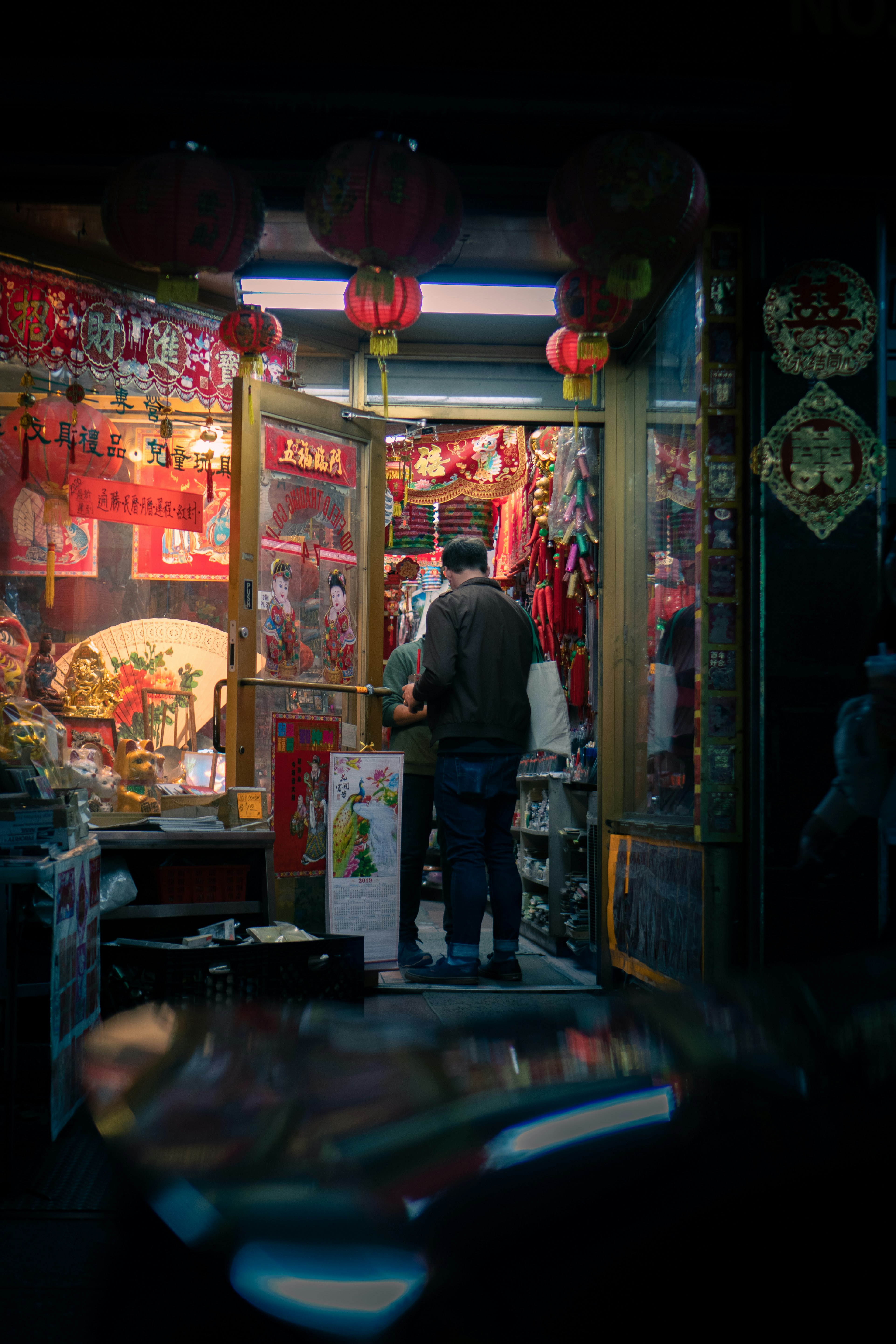 man in black jacket standing in front of store